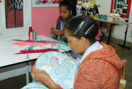 Brodeuse au travail dans l'atelier de Patchwork Creation